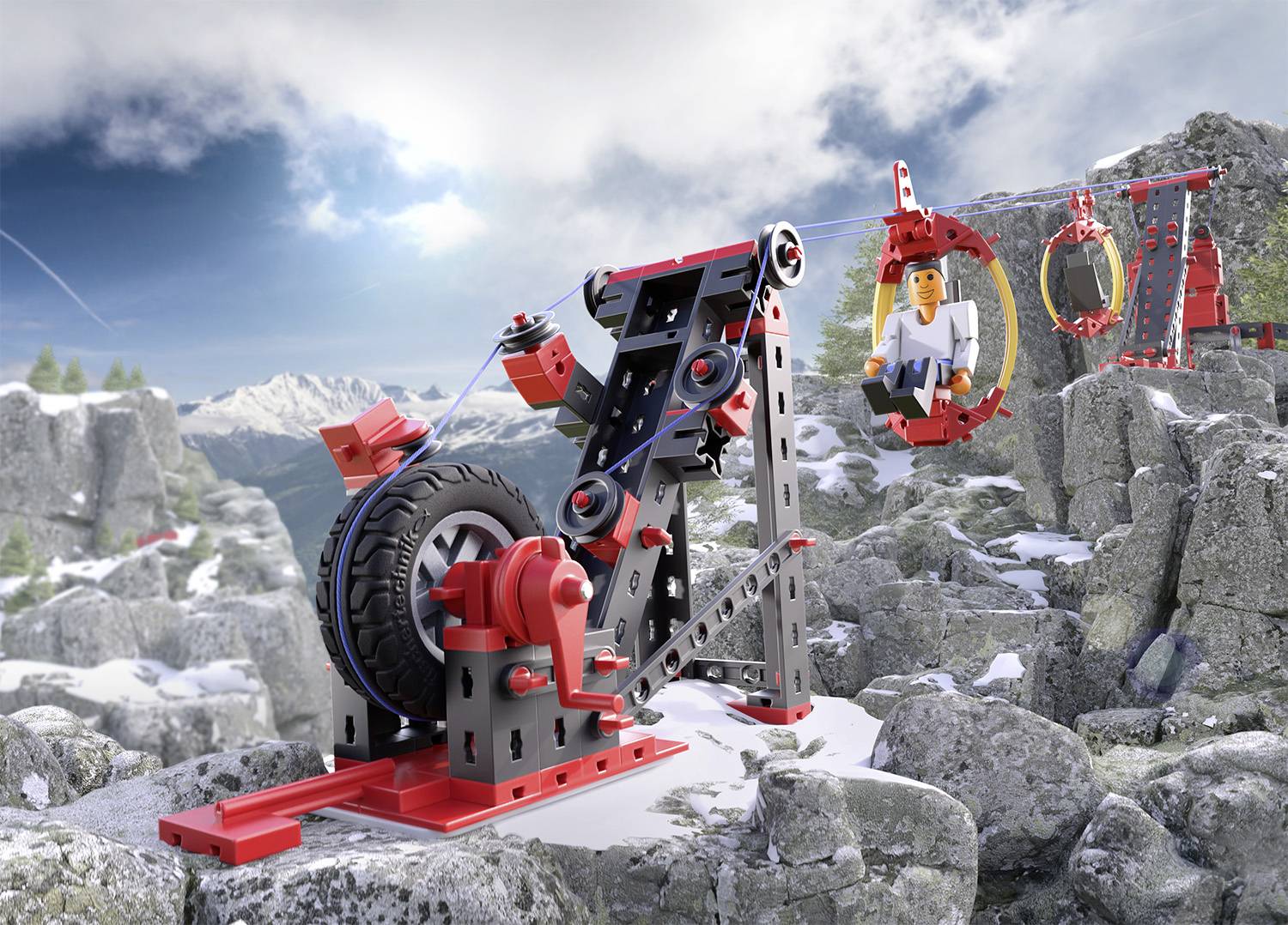 Lego sestava na zasněžené hoře zobrazuje lanovku s kabinou, ve které sedí figurka, obklopená skalami a smrky.