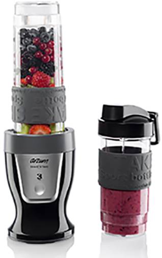 Mixér se dvěma láhvemi: Jedna láhev naplněná barevnými bobulemi, druhá červeným smoothie. Zařízení pro míchání a přenášení nápojů.