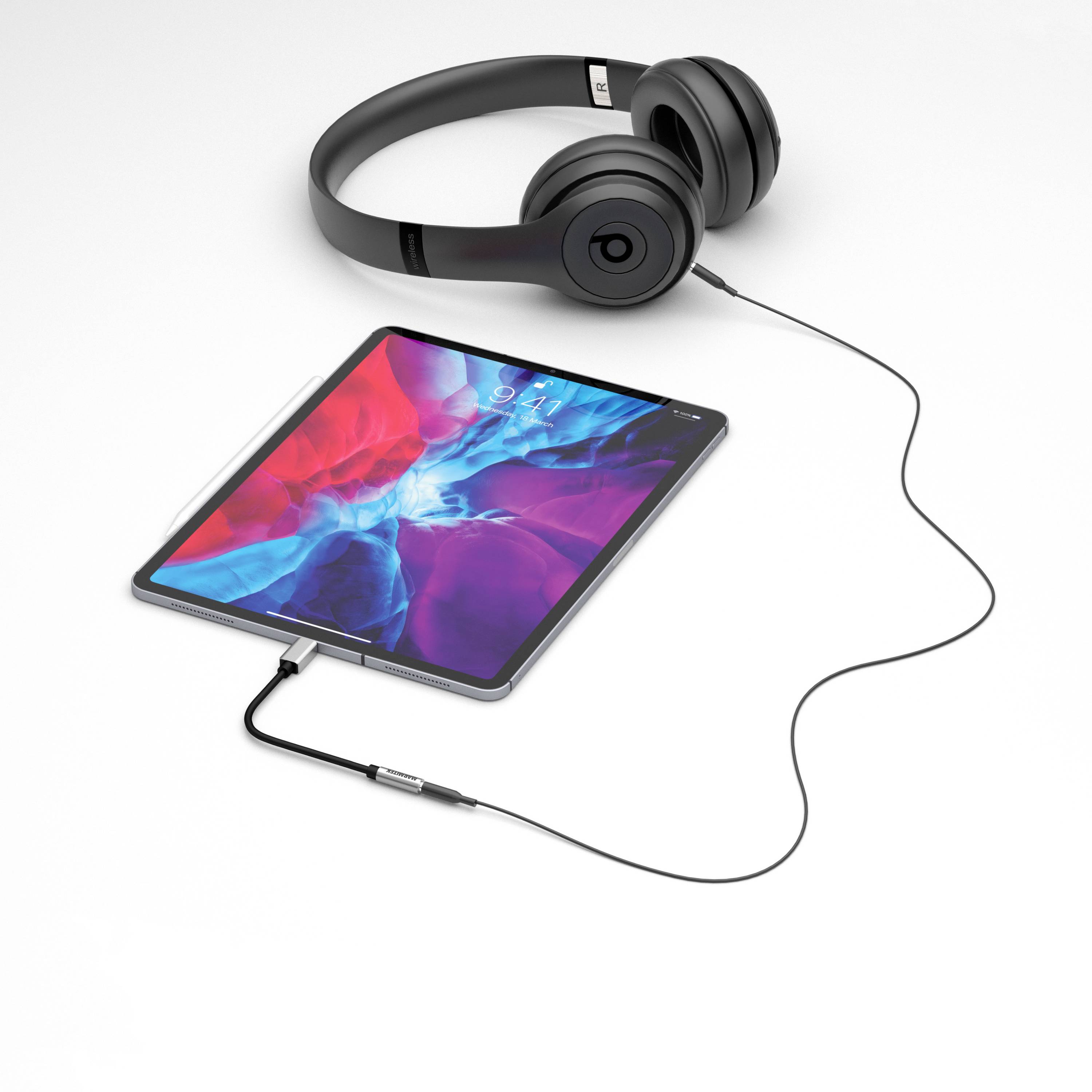 Tablet s jasným displejem, propojený černými sluchátkami kabelem.