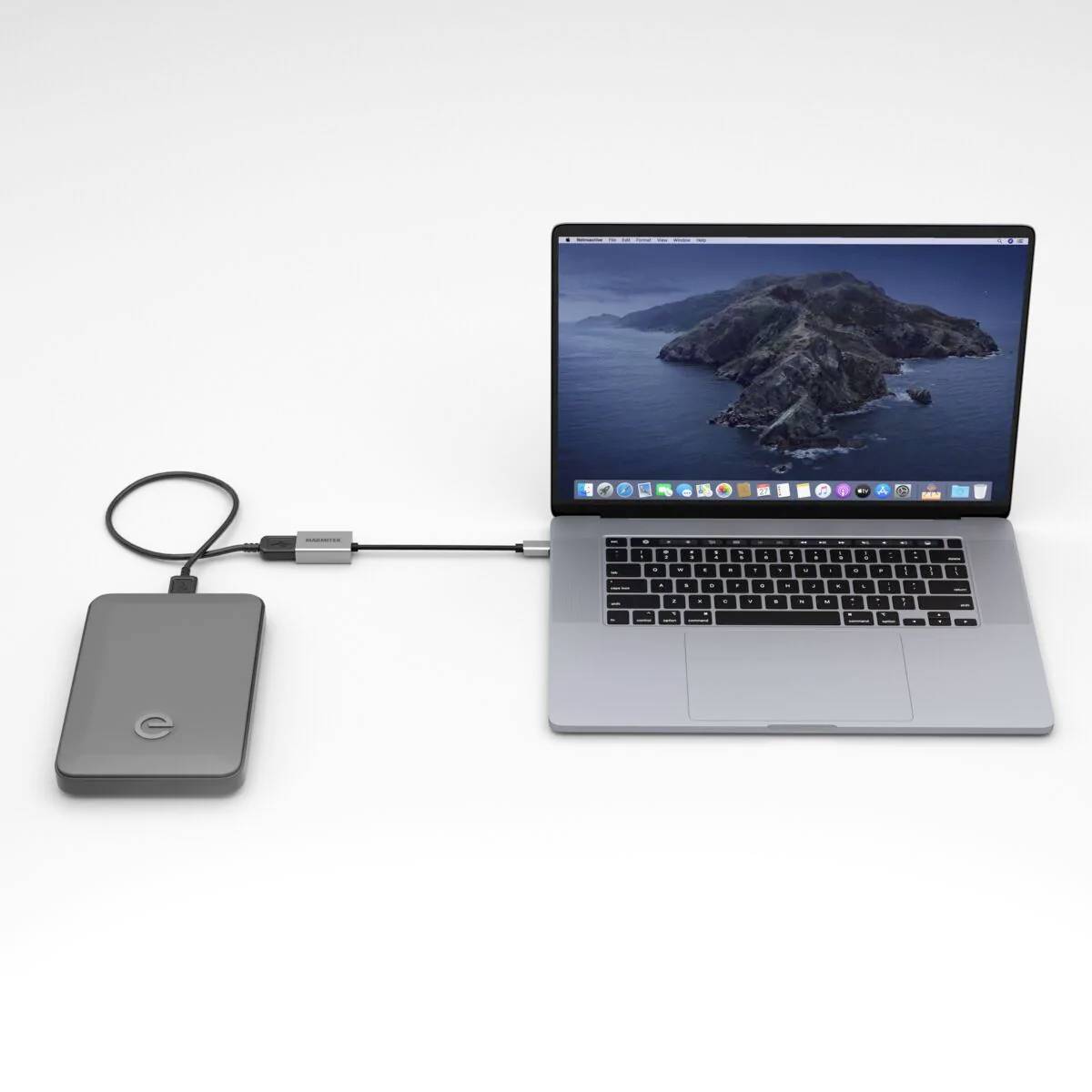 Laptop připojený k externí pevné disk. Laptop zobrazuje plochu. Kabel propojuje obě zařízení.
