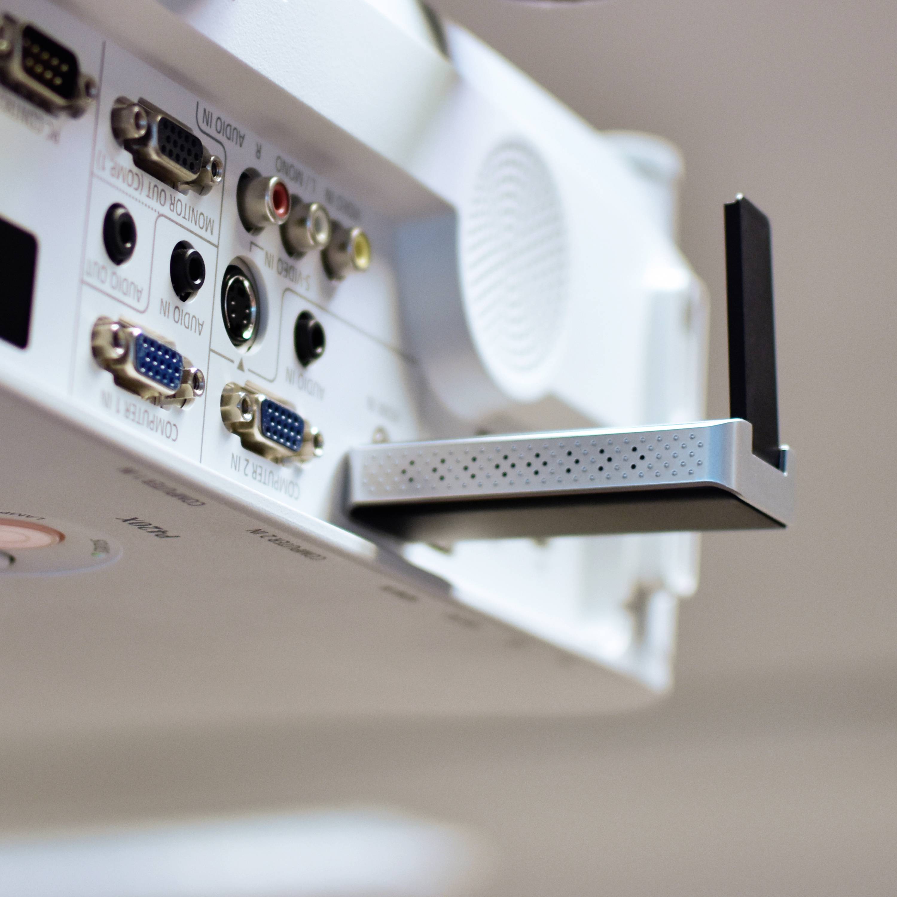 Zadní strana projektoru s několika konektory: HDMI, VGA, USB a Ethernet, včetně namontovaného modulu WLAN.