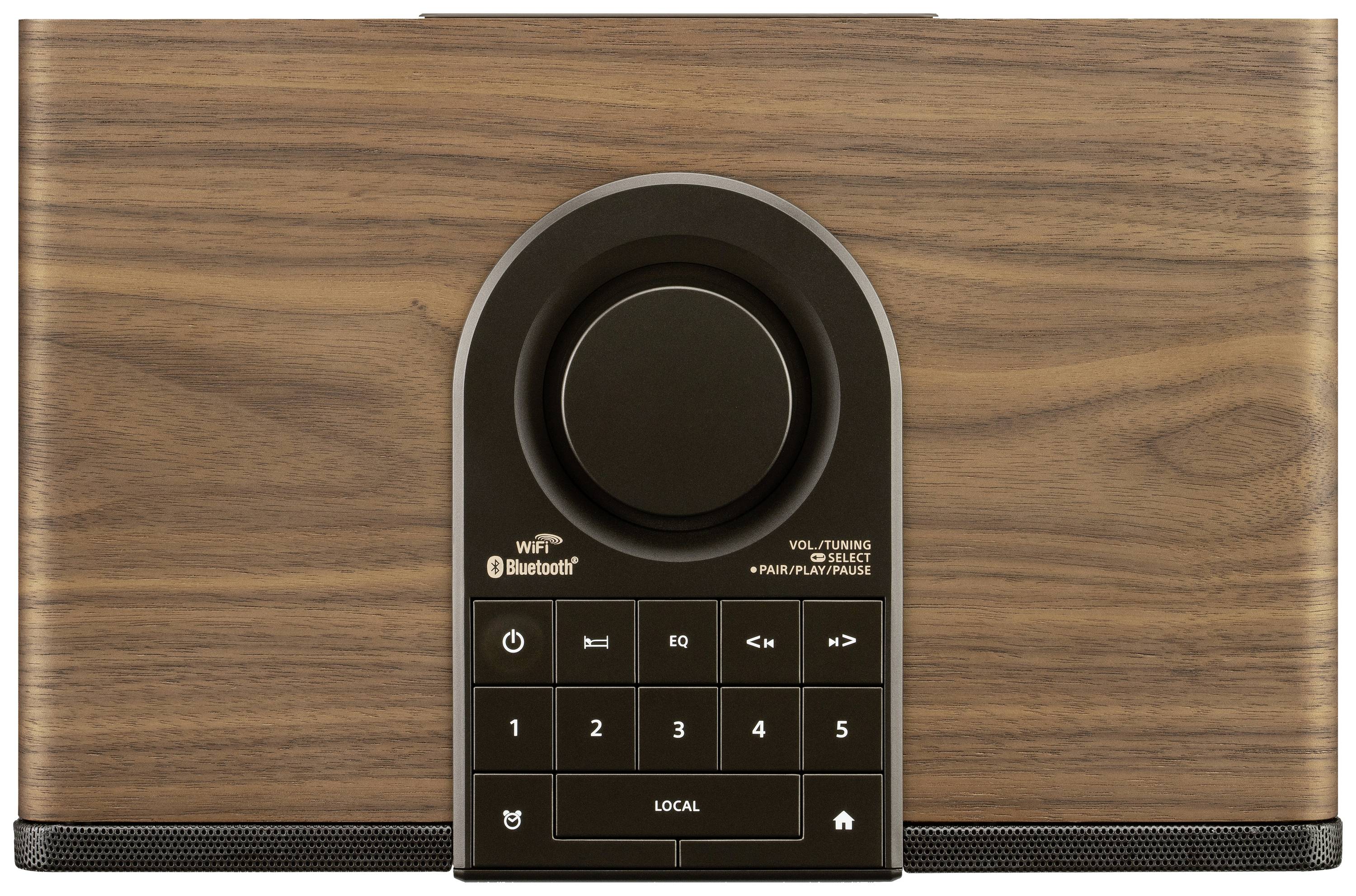 Dřevěný hudební systém s centrálním otočným ovladačem, pod ním ovládací klávesnice, s možnostmi připojení Bluetooth a WiFi.