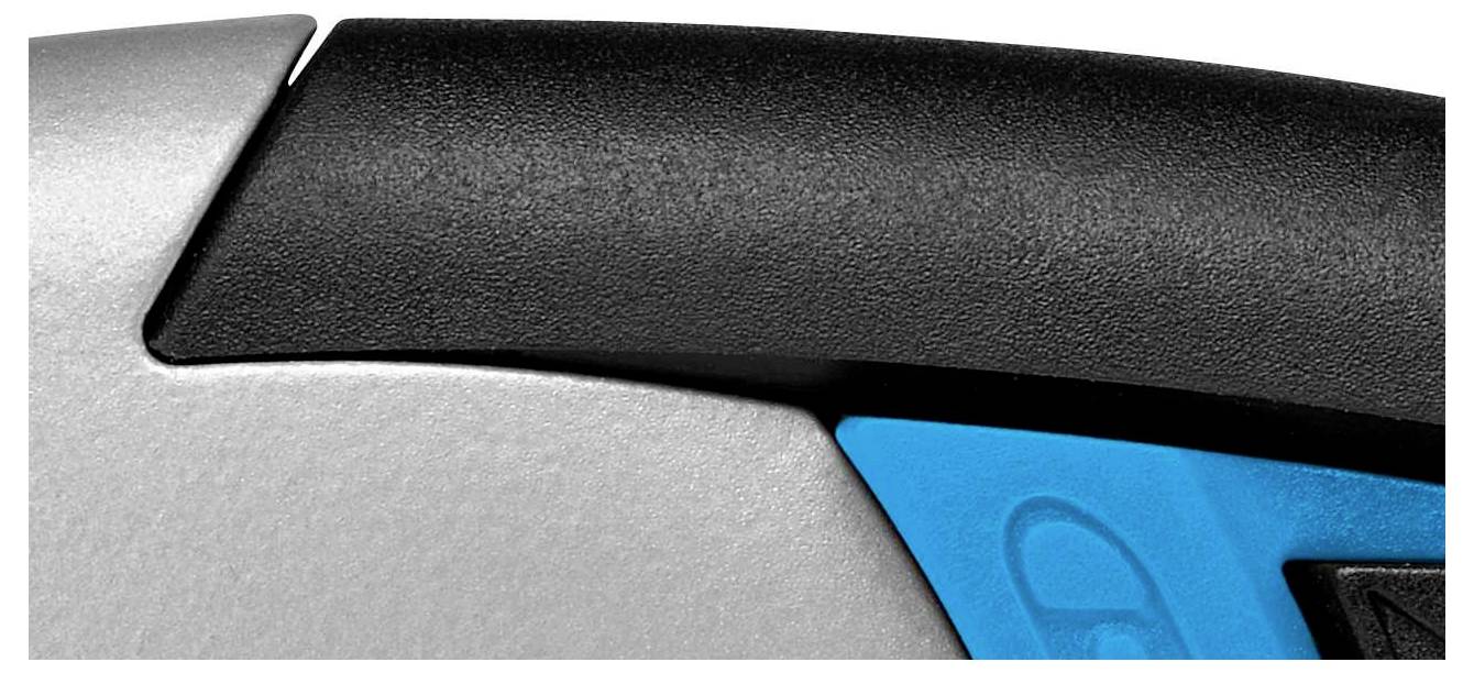 Detailní záběr objektu s stříbrným, černým a modrým povrchem. Geometrické tvary připomínají technické zařízení.
