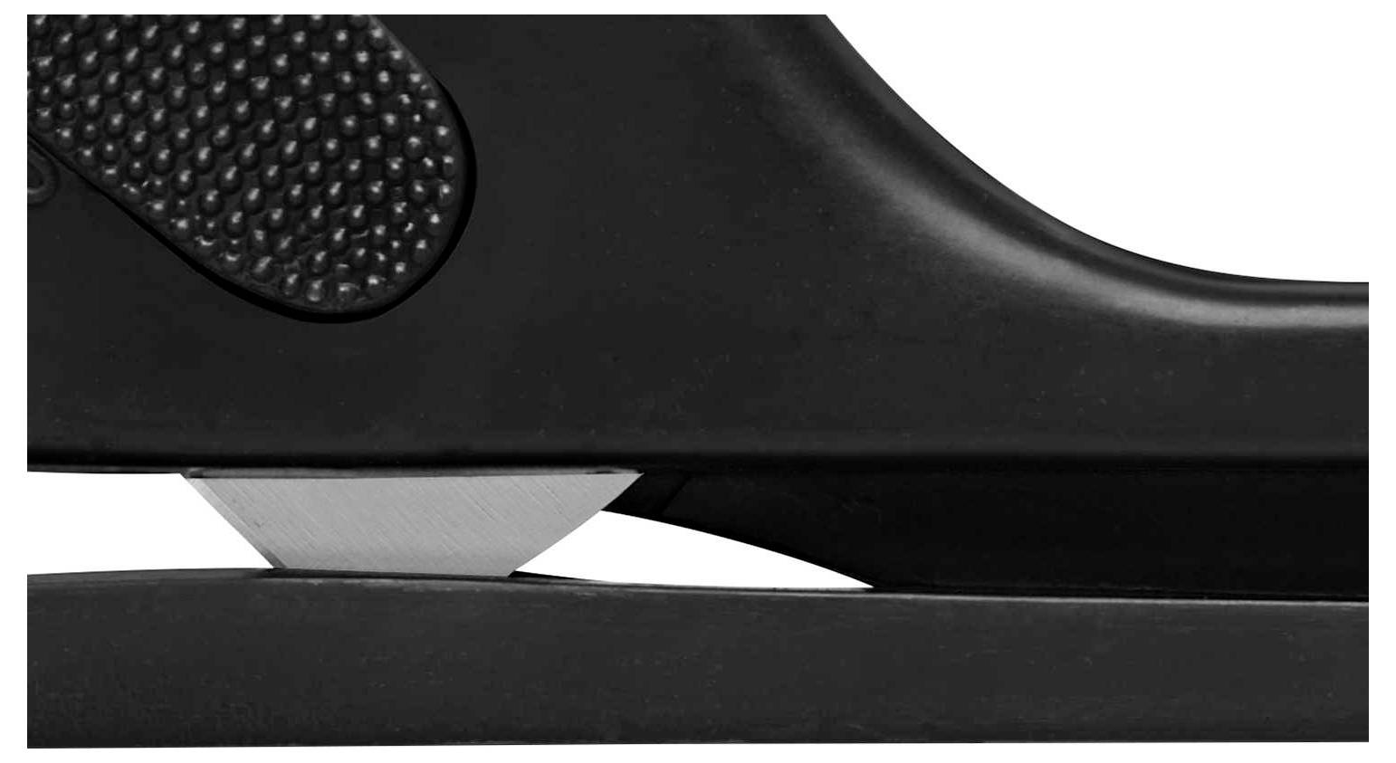 Detailní záběr černé sešívačky z boku, připravené sešít papír. Zaostřeno na kovovou čepel.