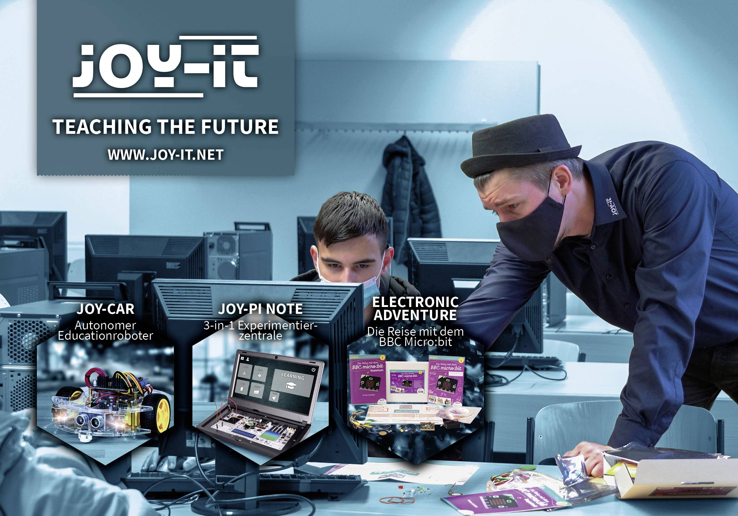 Dvě osoby spolupracují u jednoho počítače. V popředí jsou zobrazeny tři produkty: JOY-Car, JOY-Pi Note a Electronic Adventure.
