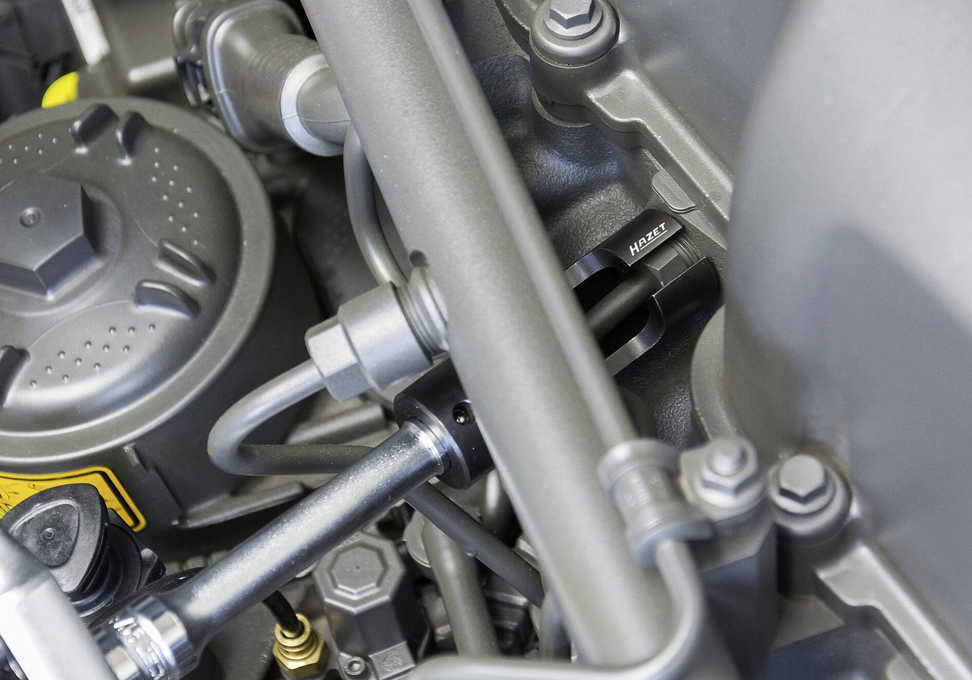 Pohled do motorového prostoru vozidla se zaměřením na různé mechanické komponenty a hadice.