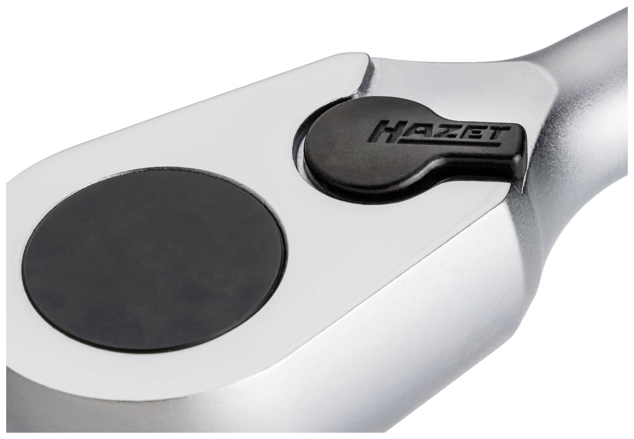 Ráčna s kulatou hlavou a značkou 'Hazet', šedé barvy, s černým tlačítkem po straně hlavy; nástroj pro mechanické práce.