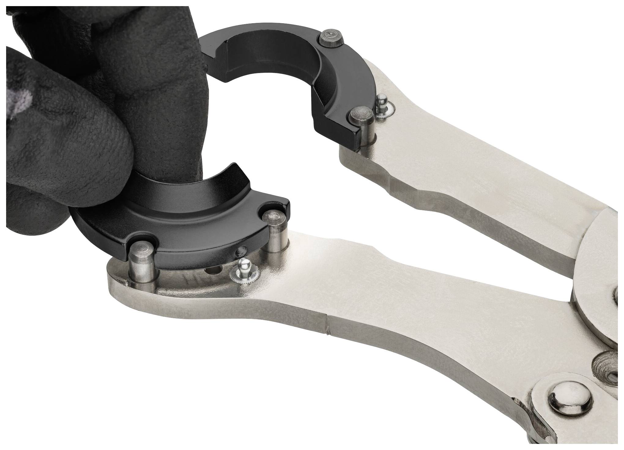 Jedna ruka v černé rukavici drží dvoudílné kovové zařízení.