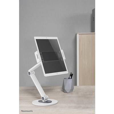 Bílý stojan na tablet drží tablet vzpřímeně na psacím stole. V pozadí stojí nádoba s psacími potřebami.