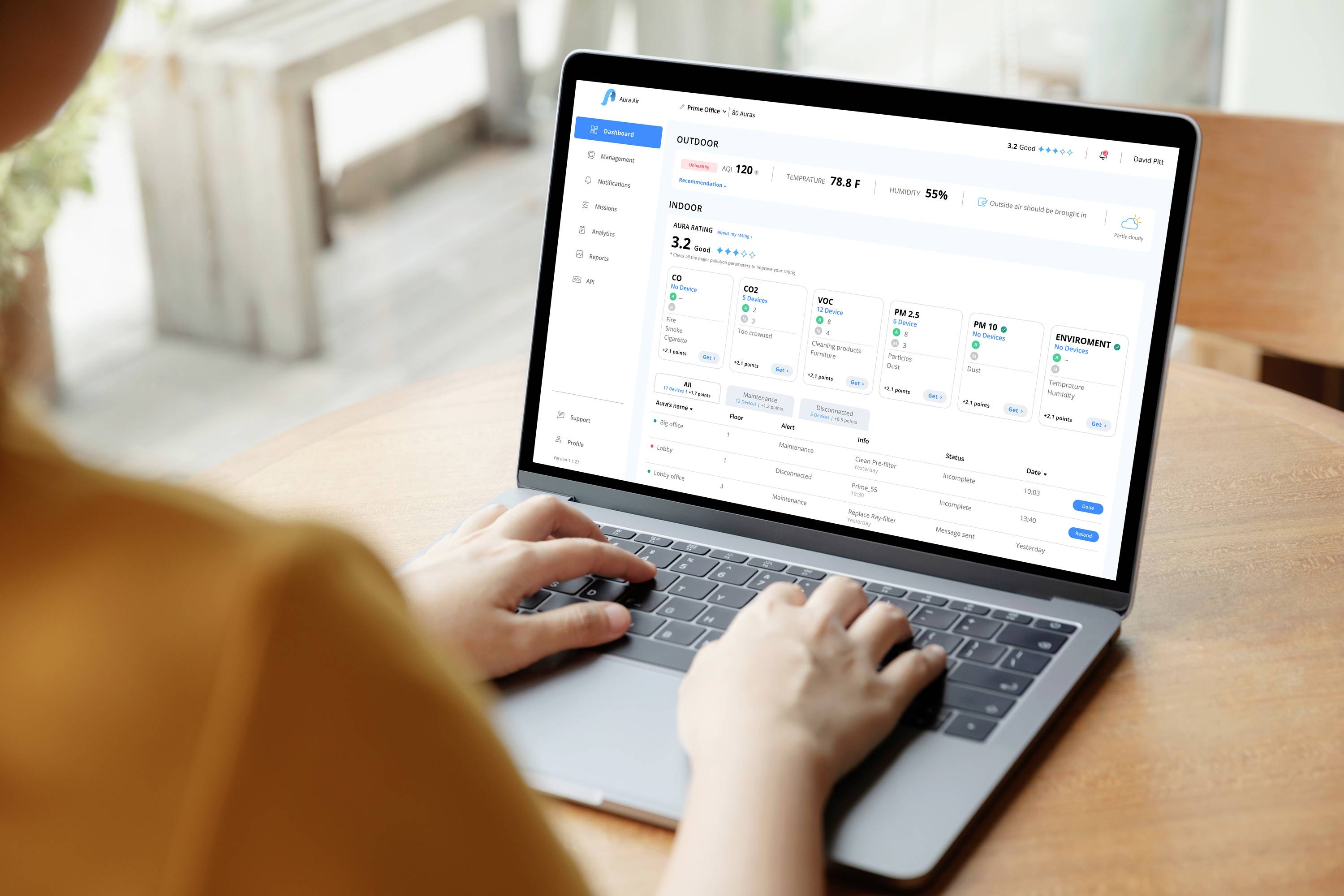 Osoba používá laptop s otevřeným podnikovým softwarem, který zobrazuje statistiky a diagramy pro řízení projektů.