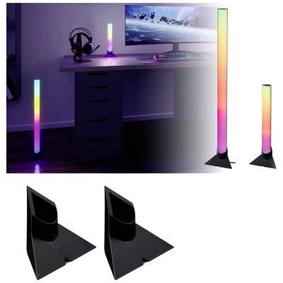 RGB světelné tyče leží na podlaze a stole tmavého herního pokoje. Svítí v různých barvách vedle počítače.