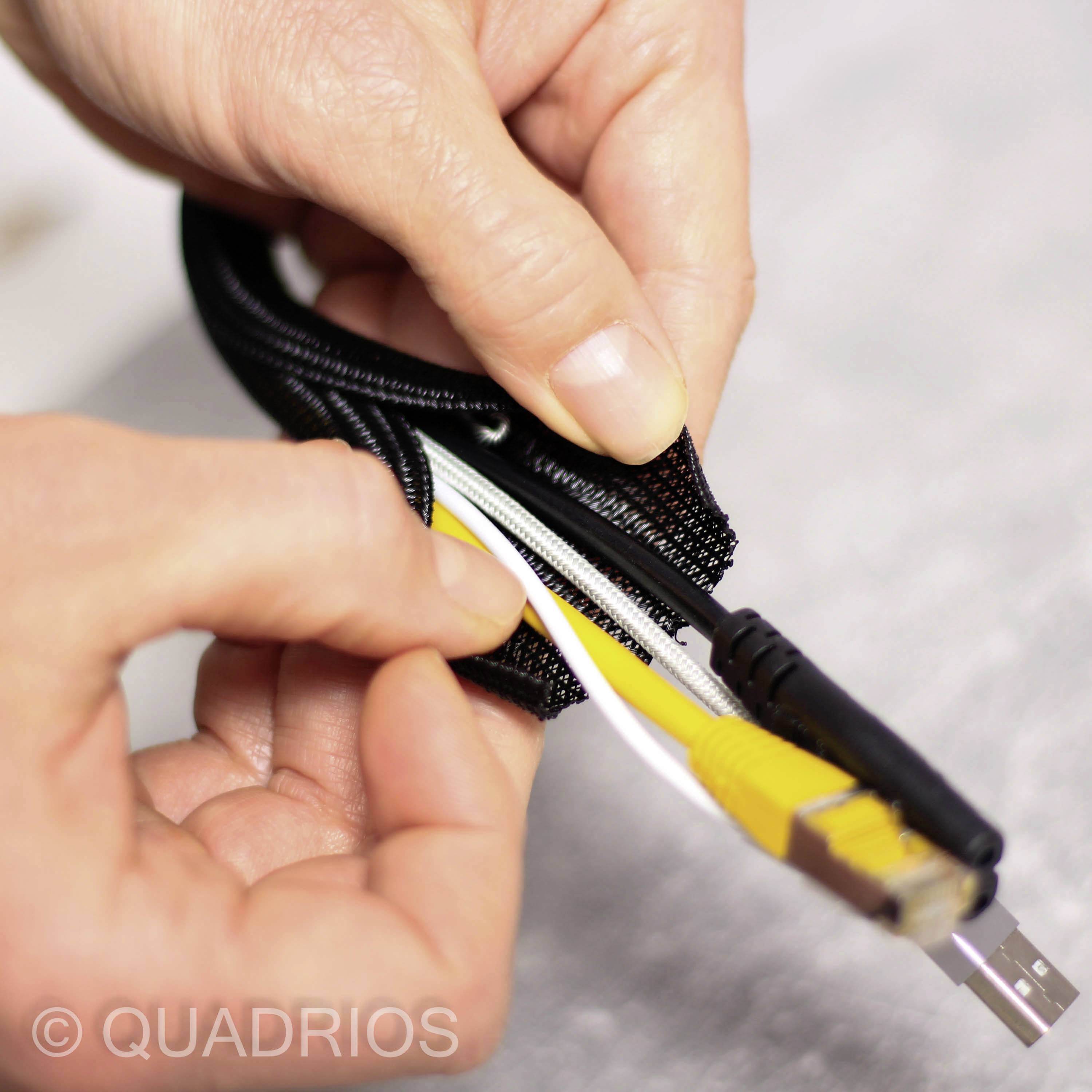 Dvě ruce upevňují kabely v černém kabelovém kanálu se zipem. Ethernet a USB kabely jsou viditelné.