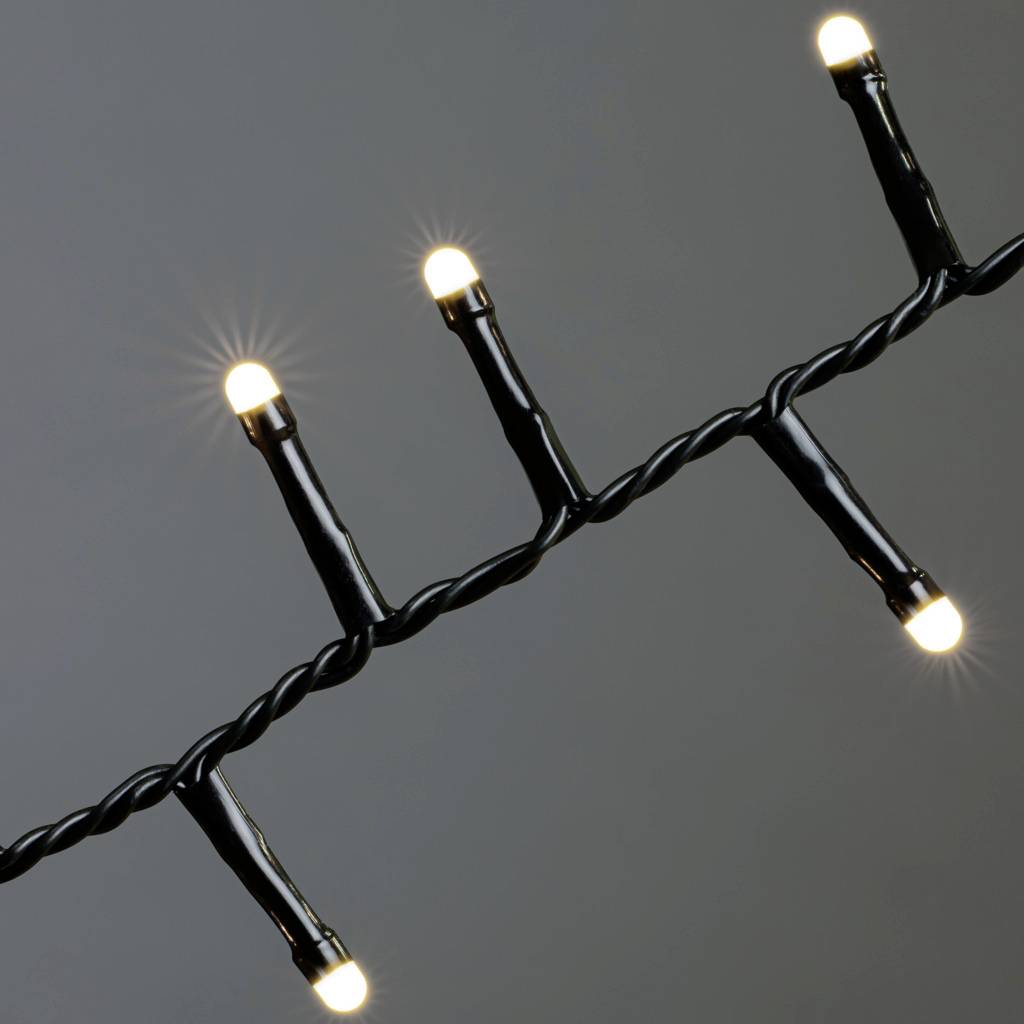 Černý drát s pěti svítícími LED lampami v diagonálním uspořádání na tmavém pozadí.