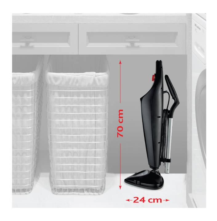 Vysavač ve vertikální poloze: výška 70 cm, šířka 24 cm. Umístěný vedle dvou košů na prádlo pod pracovní deskou.