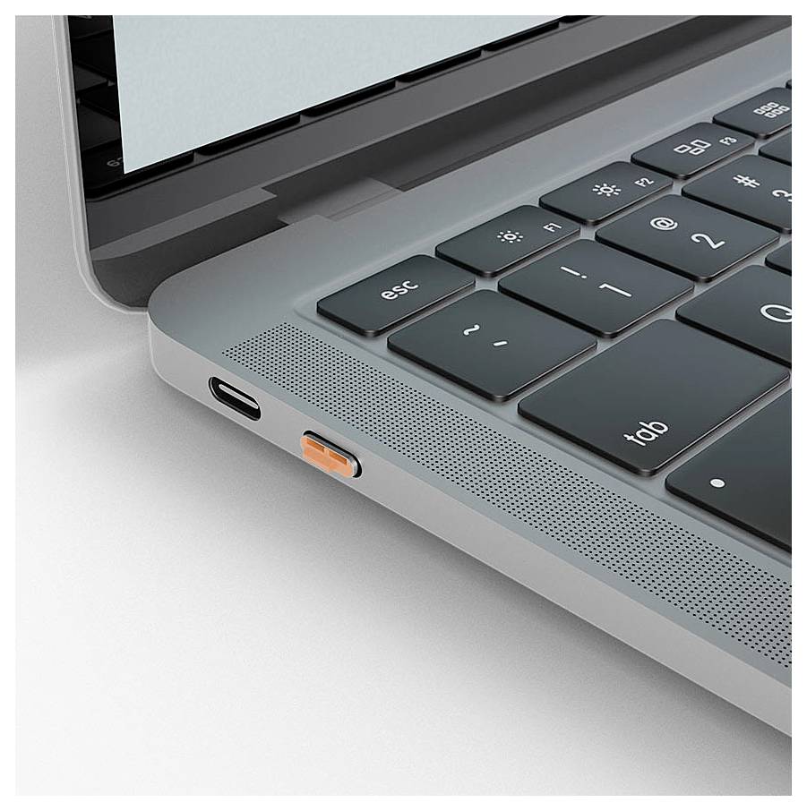 Detailní pohled na kout notebooku zobrazující klávesnici, mřížku reproduktoru a konektor pro nabíjení s připojeným oranžovým adaptérem USB-C.