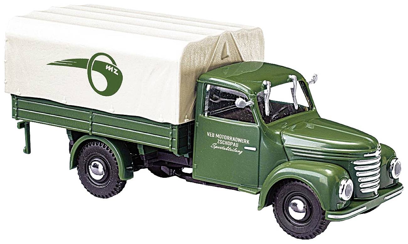 Zelený starý nákladní vůz se světlou plachtovou nástavbou a nápisem "WZ Kraftfahrzeugwerke". Retro design ve stylu modelového auta.
