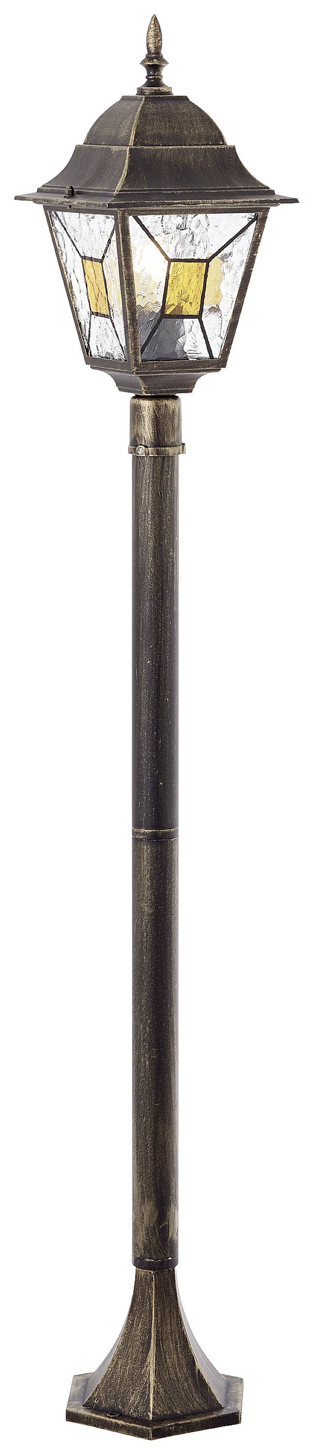 Antická pouliční lampa se vzorovanými skleněnými okny v zlatých a bronzových tónech, umístěná na vysokém, štíhlém podstavci.