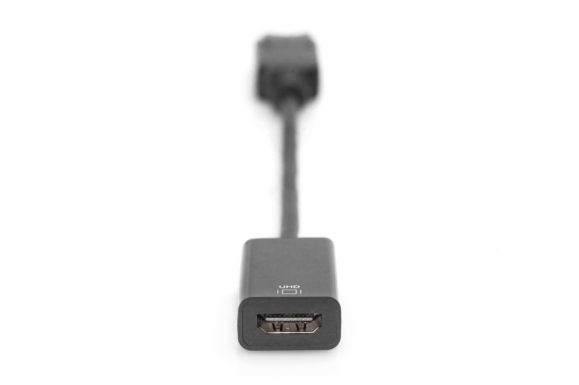 Černý HDMI adaptér, na předním plánu s HDMI zdířkou v ostření, propojovací kabel v pozadí rozostřený.