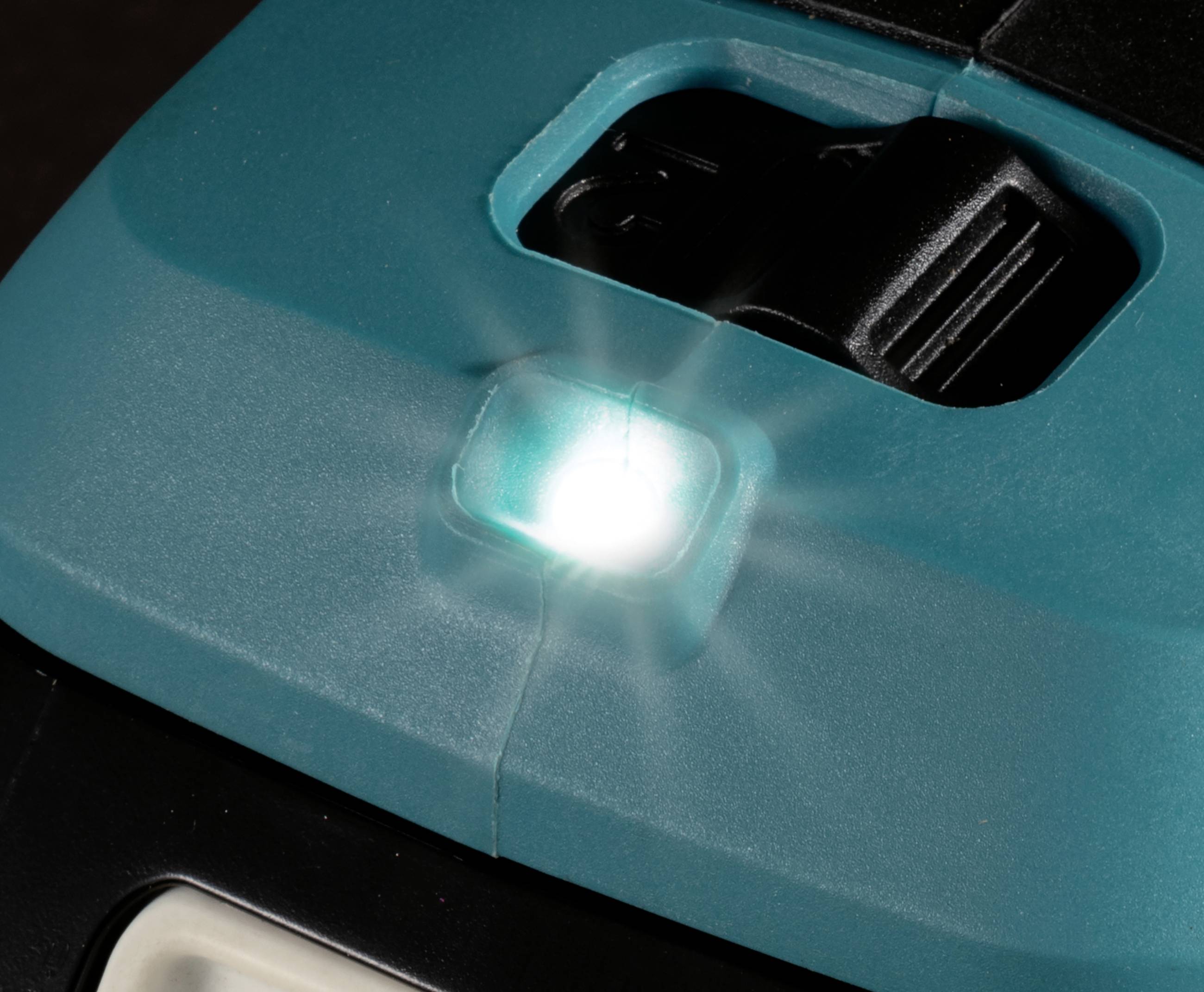 Detailní záběr ruční svítilny s rozsvícenou LED, která jasně svítí přímo do objektivu. Zařízení má modré tělo.