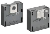 Dva obdélníkové elektronické komponenty s nápisem 'W7ED-11F' a 'W7ED-11L'. Oba mají nahoře kovové svorky.