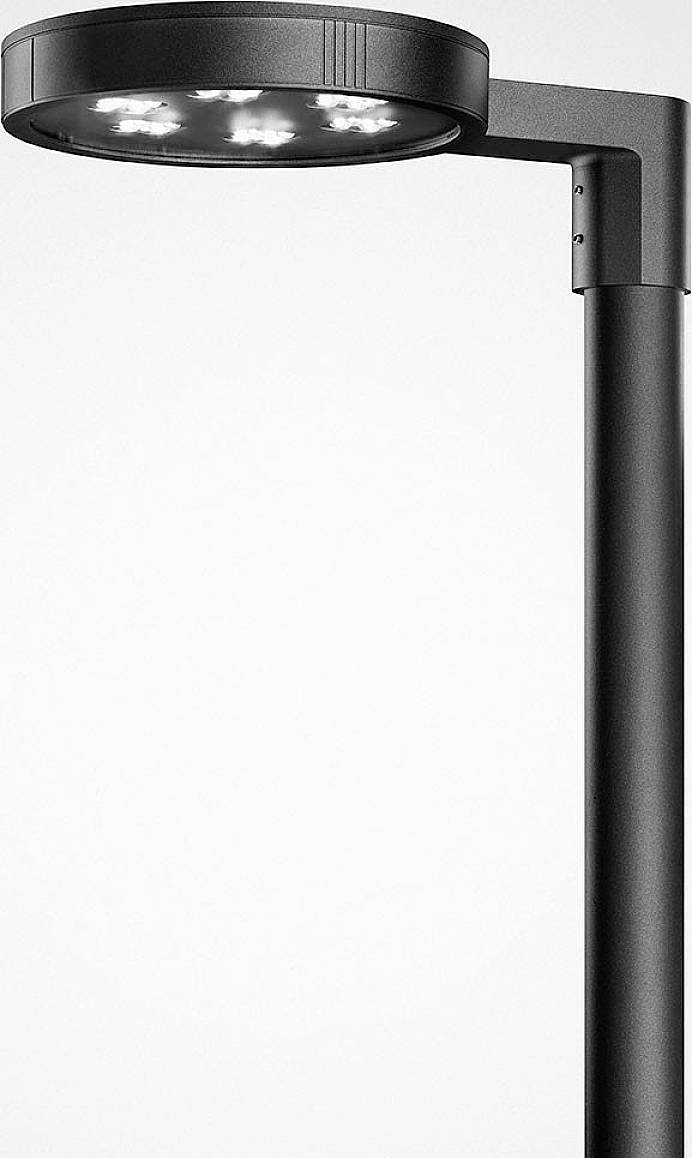 Moderní černá pouliční lampa se zakřiveným stínítkem svítí shora.