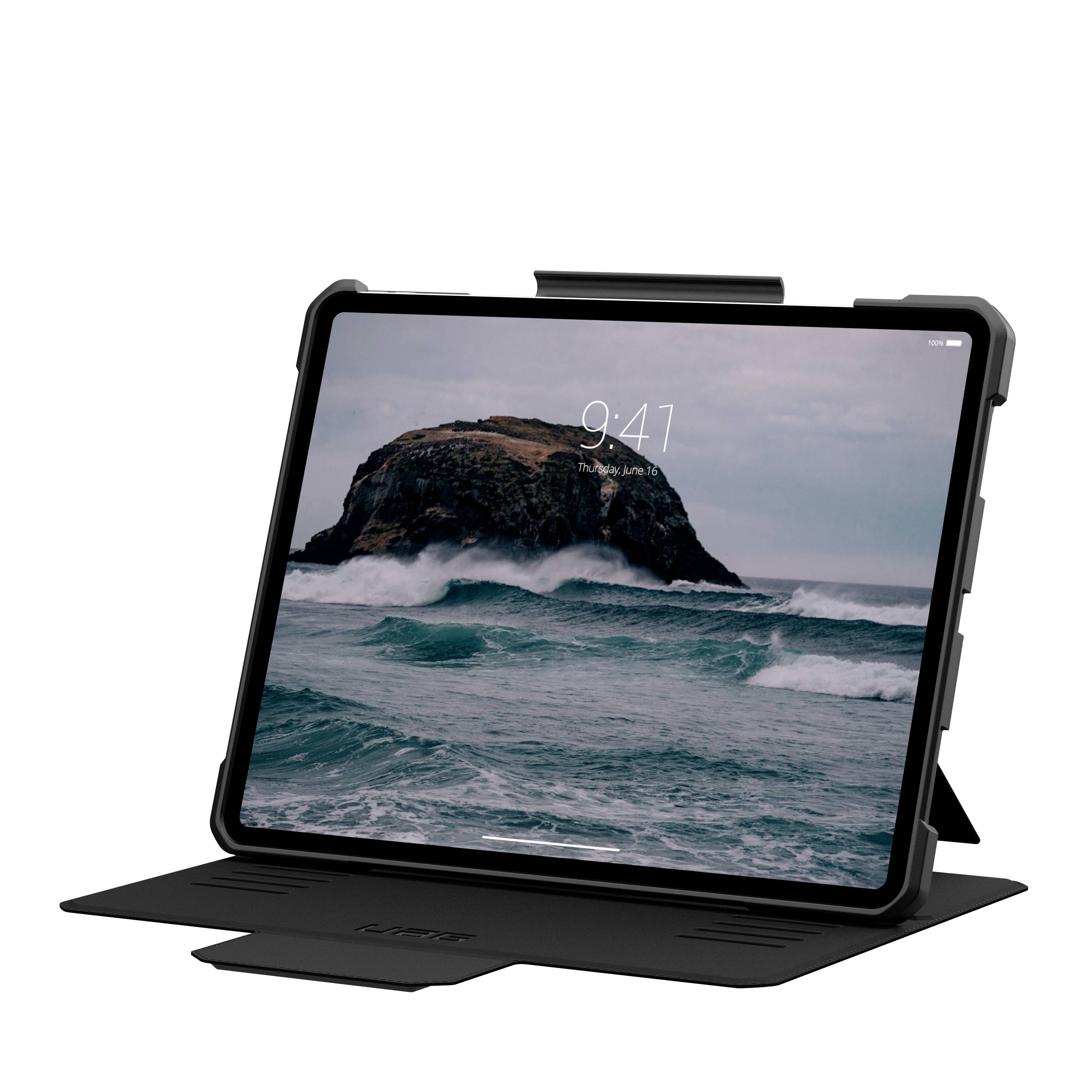 Tablet leží na stojánku a na jeho obrazovce je zobrazeno moře s vlnami a skálou v pozadí.