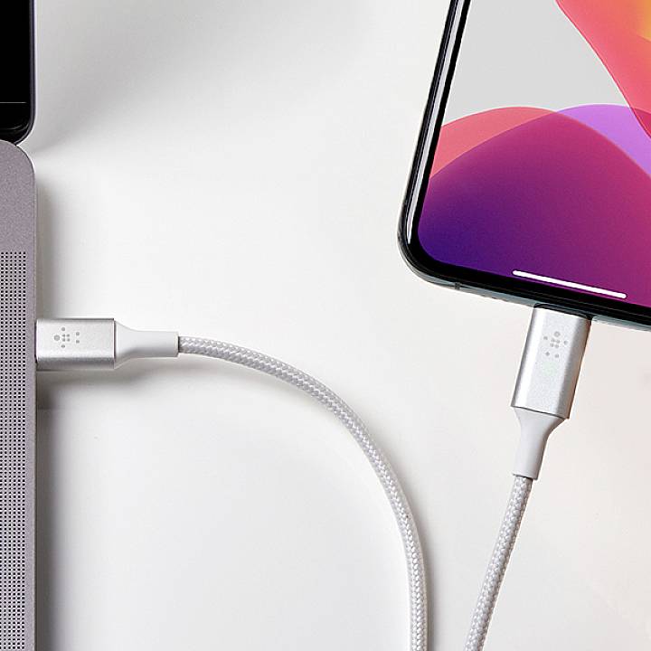 Chytrý telefon a laptop jsou současně nabíjeny pomocí nabíjecích kabelů.