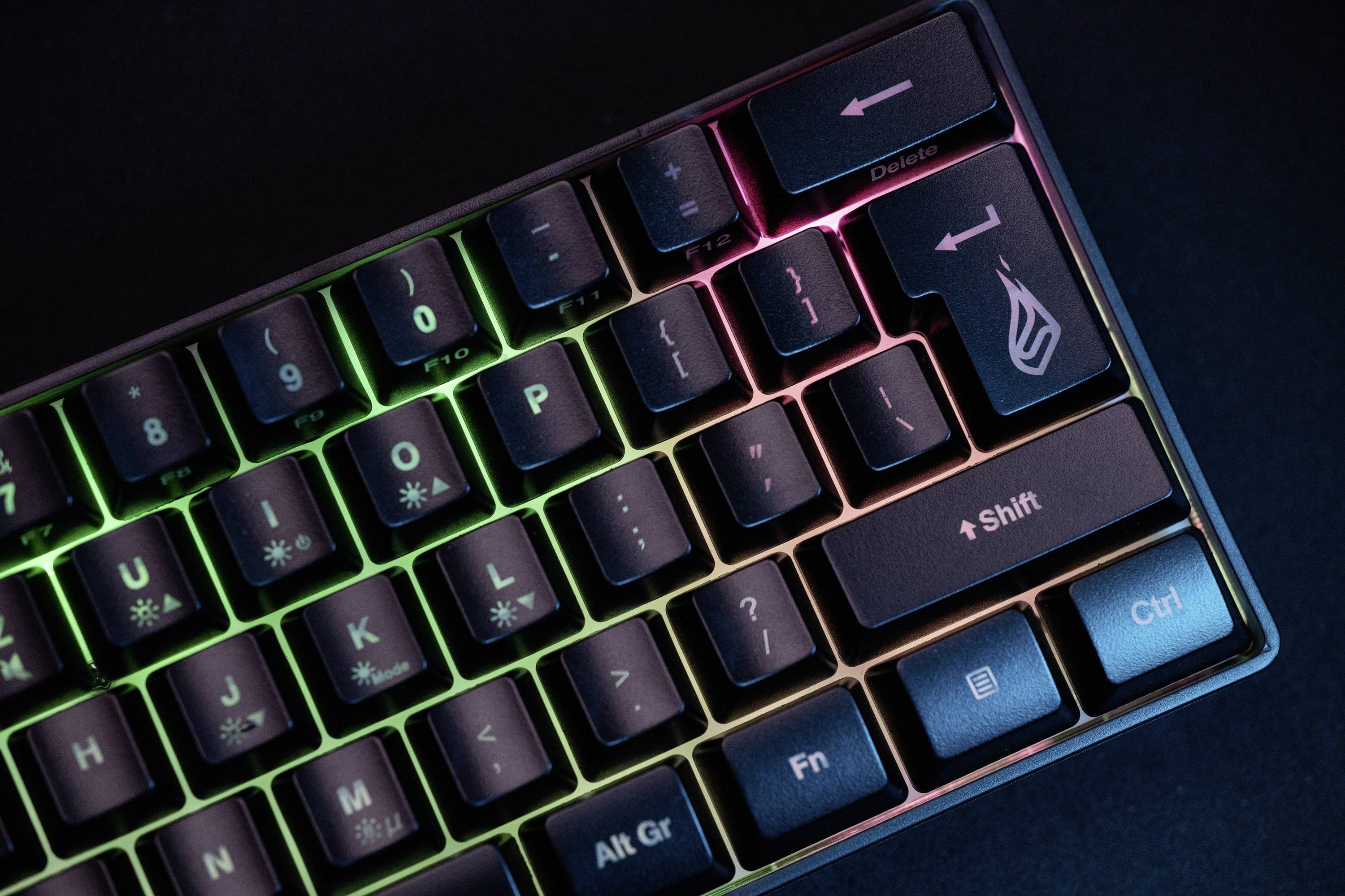 Osvětěná počítačová klávesnice s RGB barvami zobrazuje klávesy jako 'Shift', 'Enter' a 'Ctrl'. Klávesnice je dobře viditelná ve tmě.