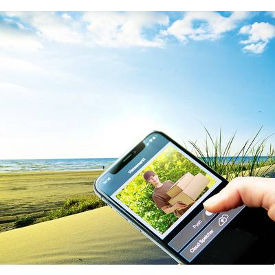 Detailní záběr smartphonu zobrazujícího objednávkovou obrazovku. V pozadí slunečný beach s modrým nebem a trávou.