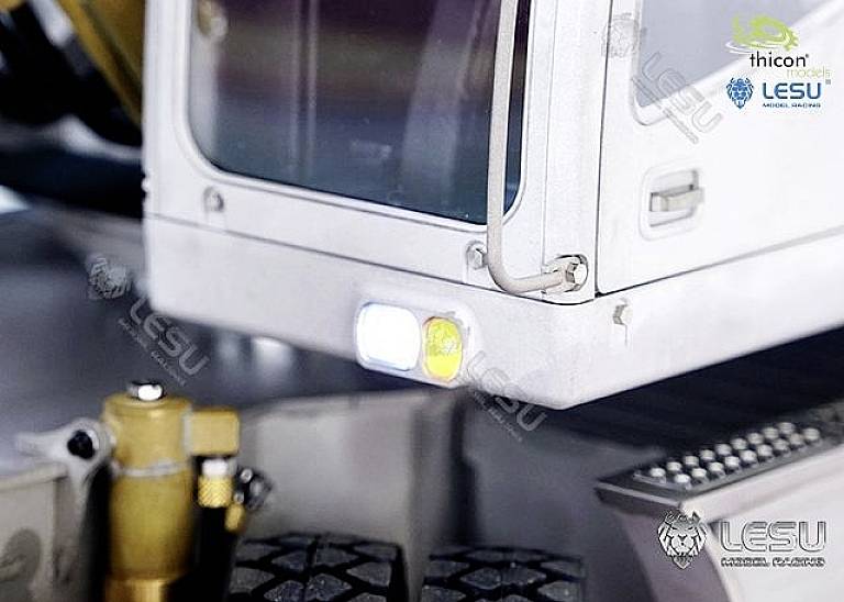 Detailní záběr modelářského dílu s osvětlením a několika mechanickými prvky. Viditelná loga společností 'thicon models' a 'LESU'.