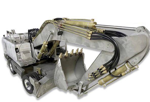 Stříbrný bagr s velkými hydraulickými rameny a lžící, který je v provozu na stavebním místě. Hlavní důraz je kladen na lžíci a hydraulický systém.