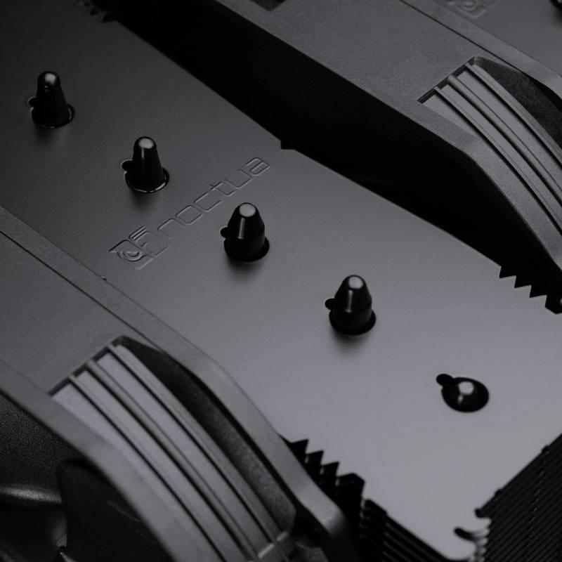 Detailní záběr černého chladiče s logem 'Noctua', který ukazuje technické detaily a texturu.