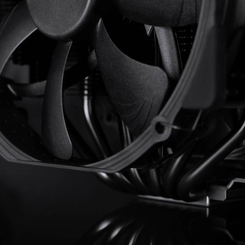 Detailní záběr počítačového ventilátoru s několika lopatkami namontovanými v počítačové skříni. Ventilátor je černý a působí průmyslovým dojmem.