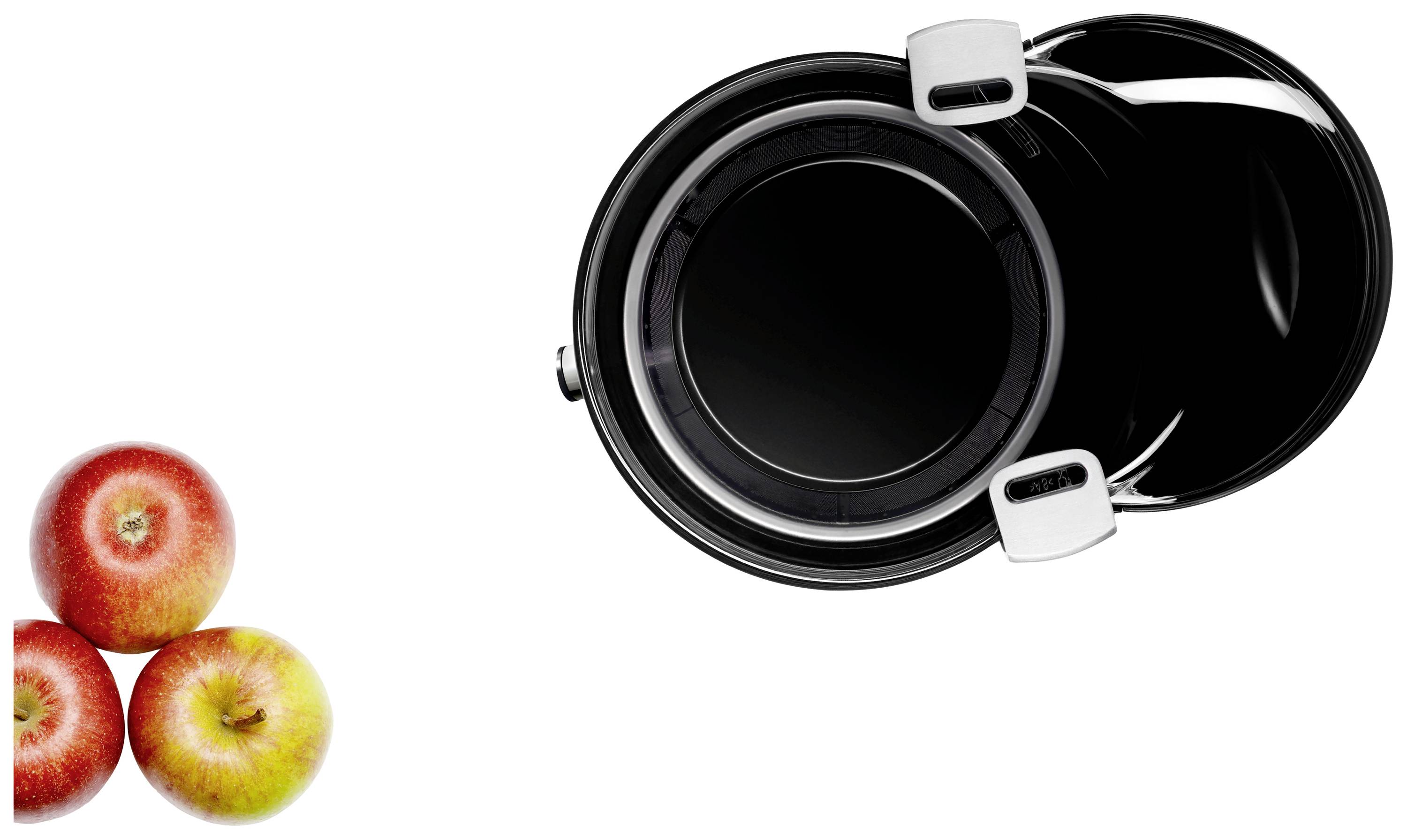 Tři jablka vedle černého hrnce s stříbrnou rukojetí, pohled shora.