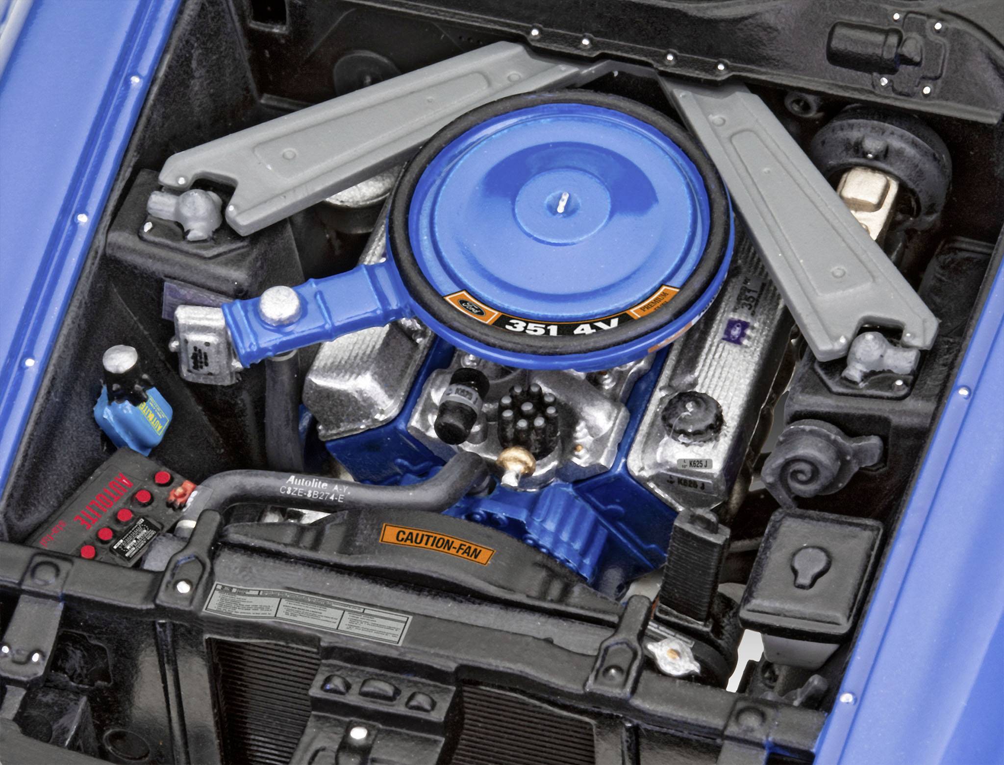 Motorový prostor Fordu s modrým vzduchovým filtrem a nápisem '351 4V'. Je vidět mnoho kabelů a mechanických součástí.