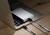 Přenosné externí úložiště je připojeno k laptopku pomocí dvou kabelů, který stojí na dřevěném stole.