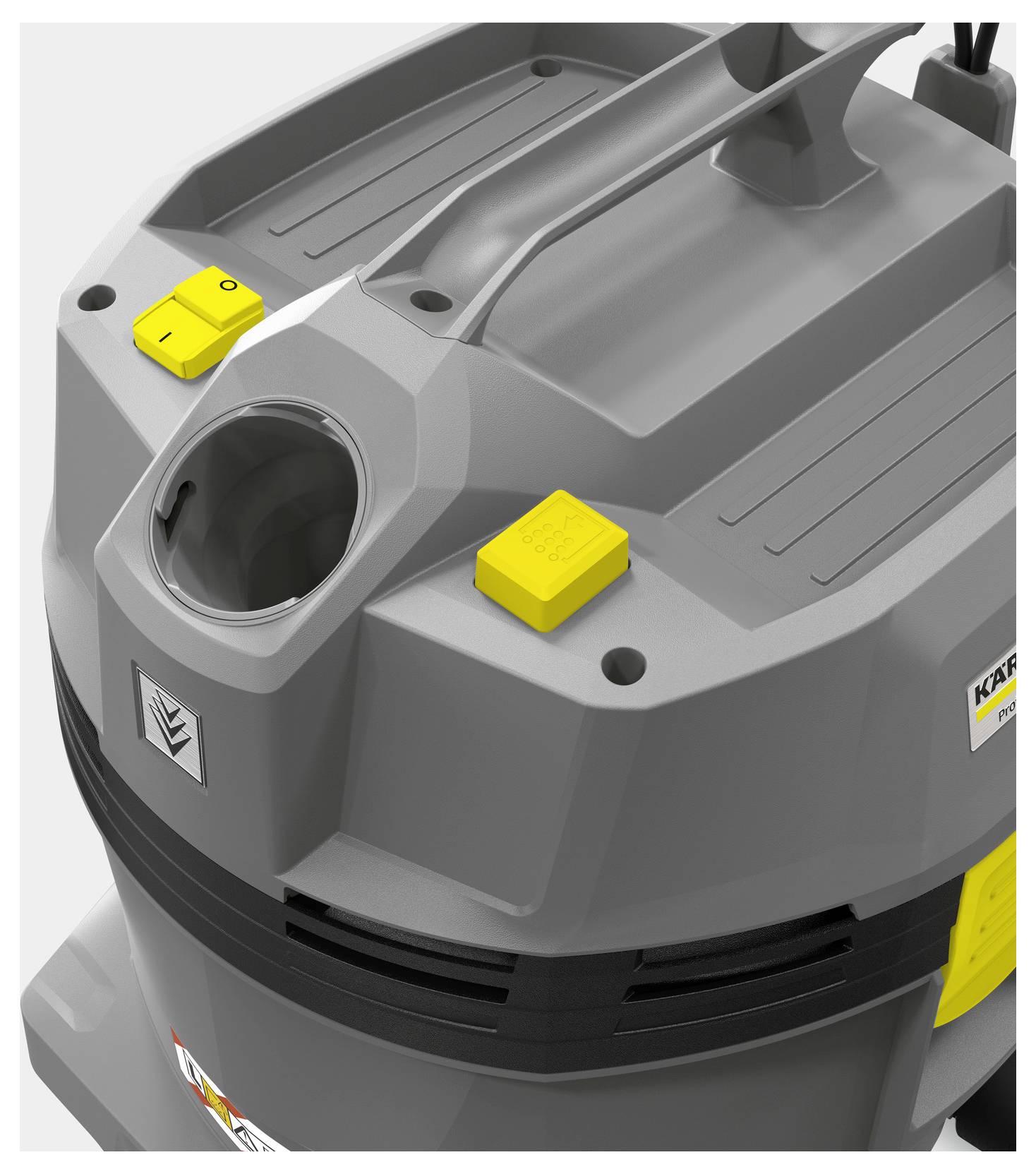 Šedý průmyslový vysavač s žlutým spínačem napájení a velkou rukojetí nahoře. Stroj má robustní, hranaté konstrukční řešení.