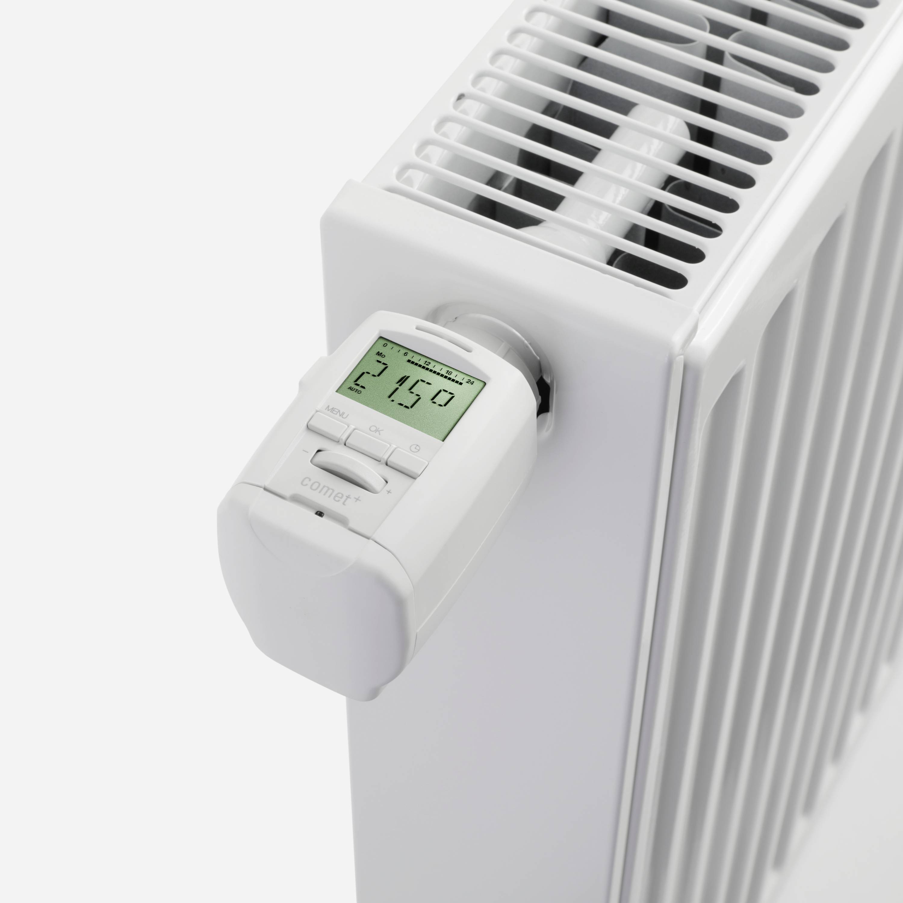 Bílé topné těleso s integrovaným digitálním termostatem, který ukazuje '21,5 stupňů', což naznačuje požadovanou teplotu v místnosti.