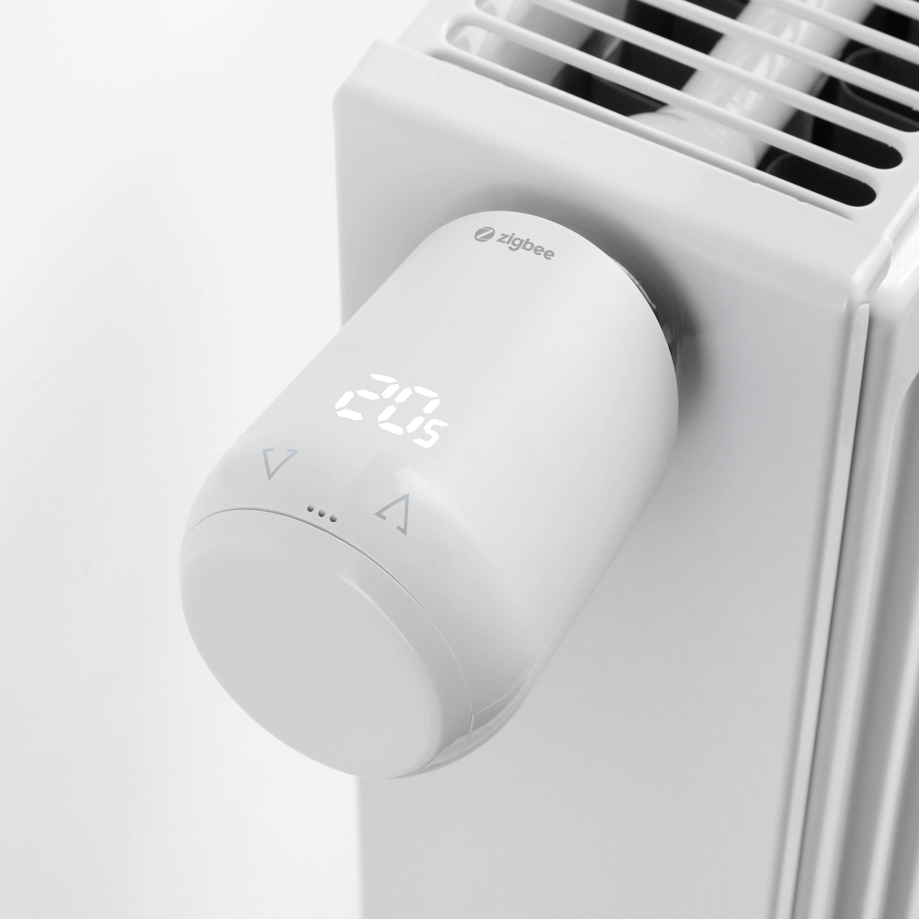 Termostatická hlavice na radiátoru s digitálním displejem, ukazuje 20,5 stupňů Celsia.