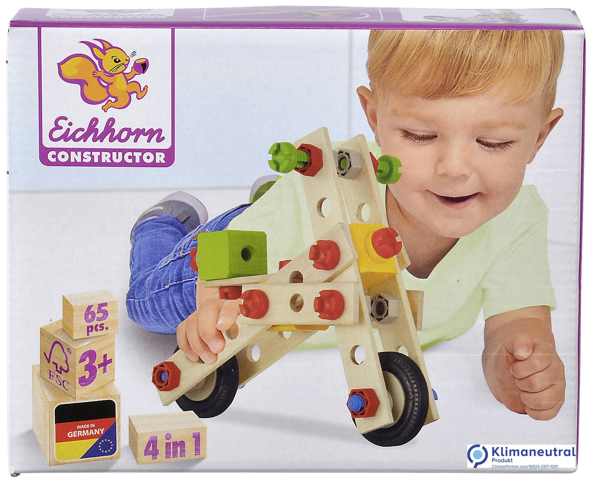 Dítě si hraje se stavebnicí 'Eichhorn Constructor', ze které bylo sestaveno vozidlo. Vpravo dole je logo 'Klimaticky neutrální'.