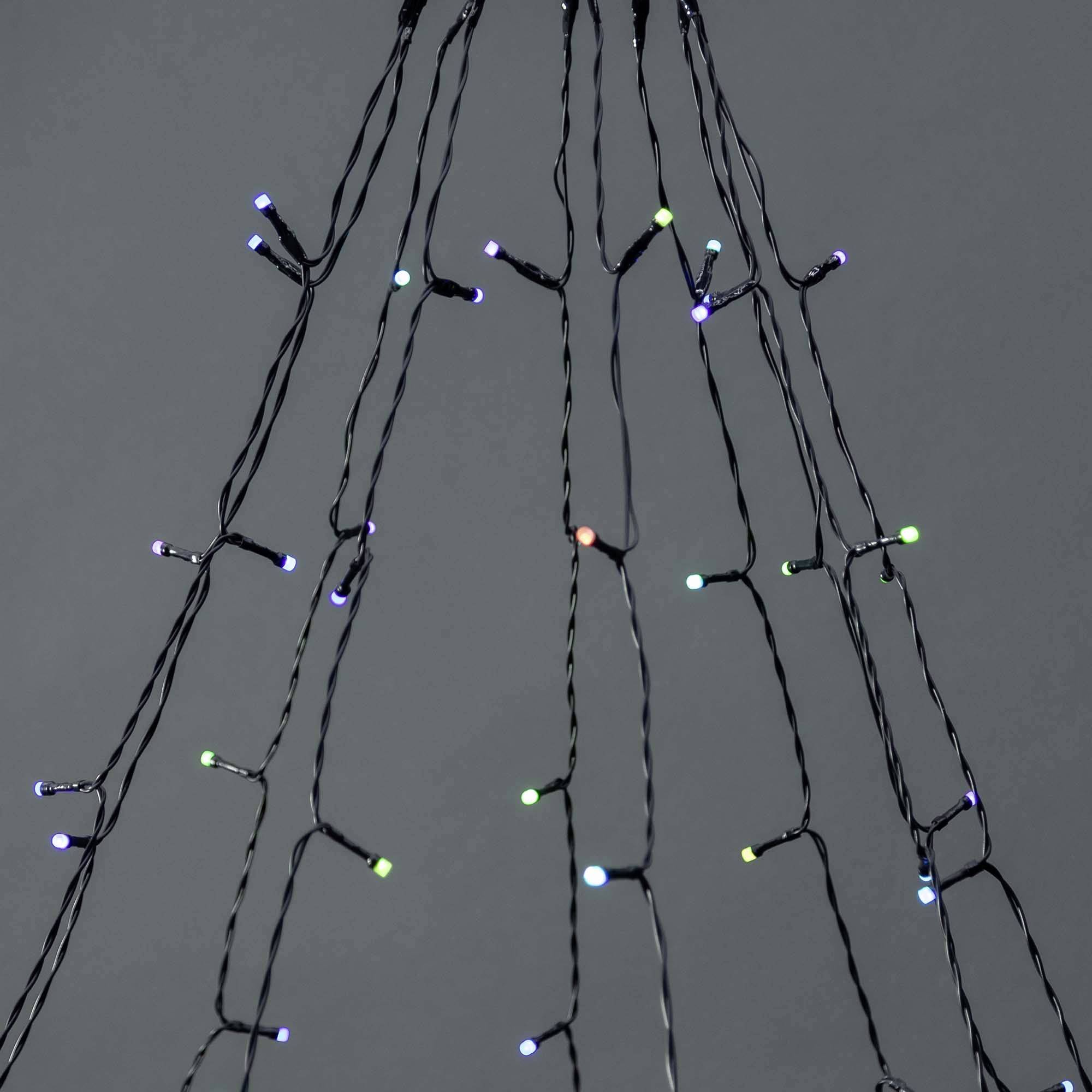 Barevné světelné řetězy visí shora, září v různých barvách na šedém pozadí a šíří sváteční atmosféru.