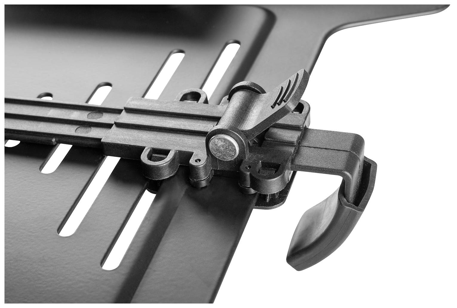 Černá kovová mřížka s nastavitelným uzavíracím mechanismem, pravděpodobně součást grilu nebo pece, pohled zblízka.