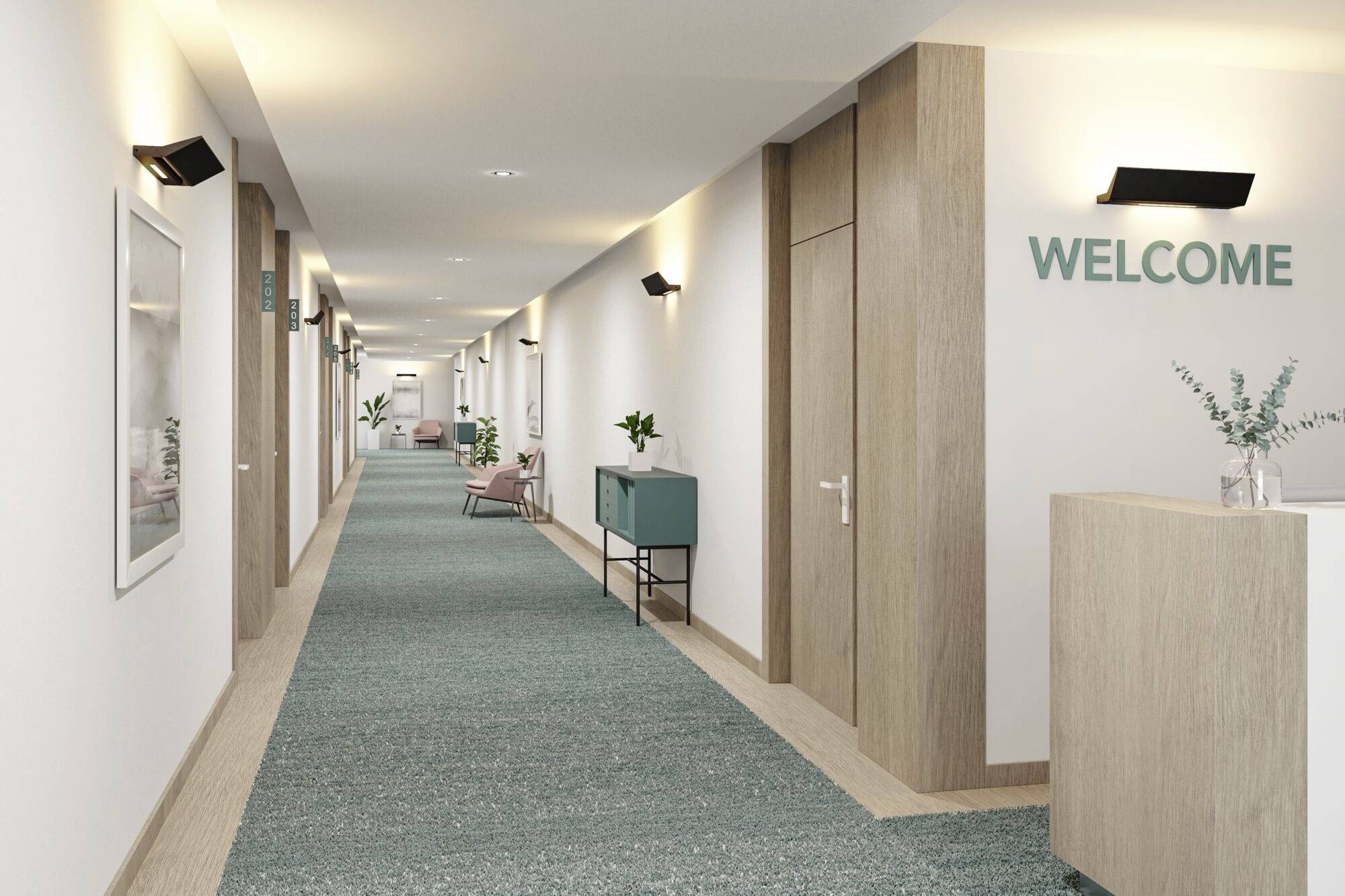 Dlouhá, moderně řešená chodba s zeleným kobercem. Na stěně visí cedule s nápisem 'WELCOME'.