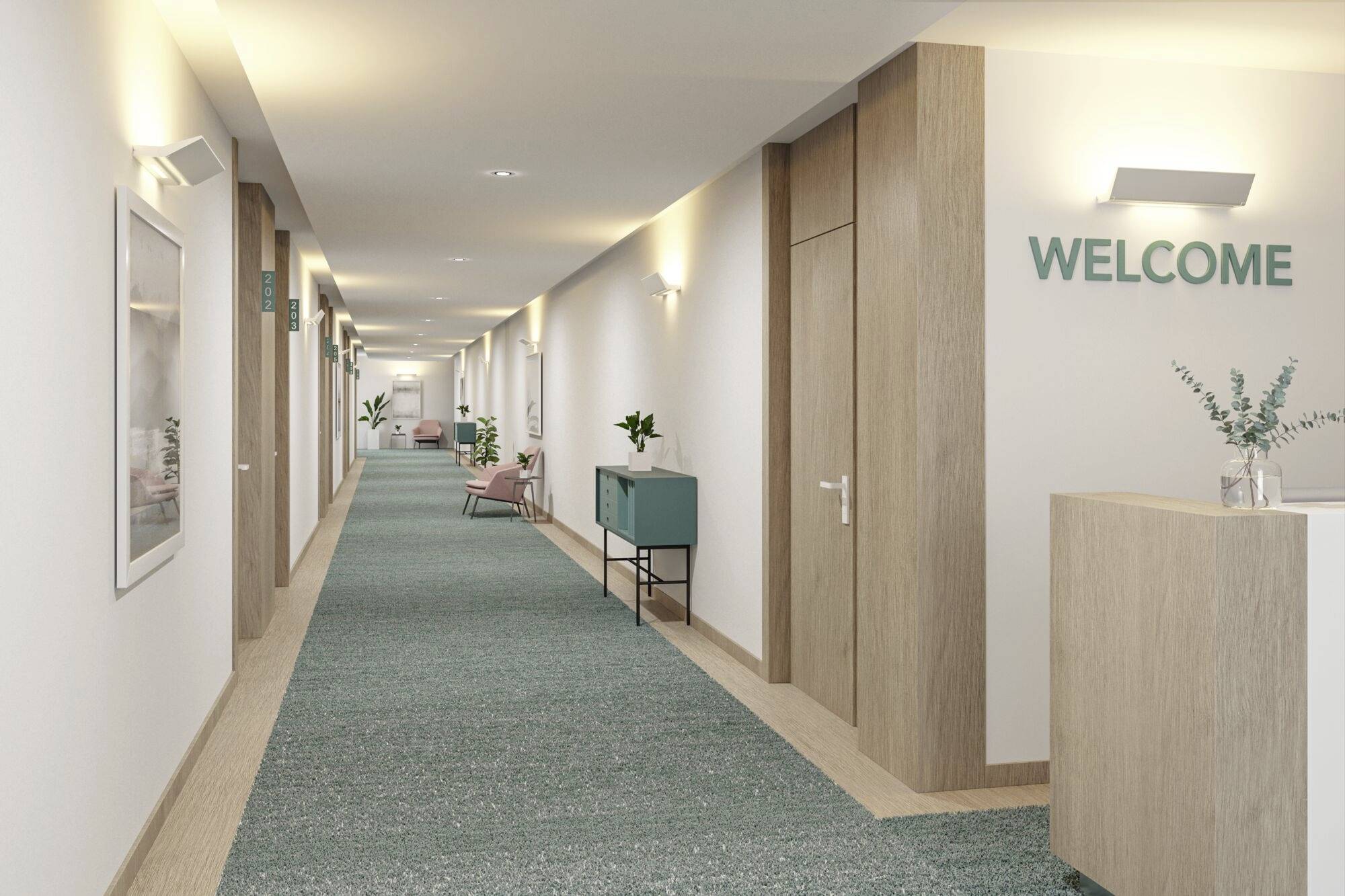 Dlouhá chodba v moderní budově, béžové stěny, tyrkysový koberec, dřevěné prvky, rostliny a nápis 'WELCOME' na stěně.