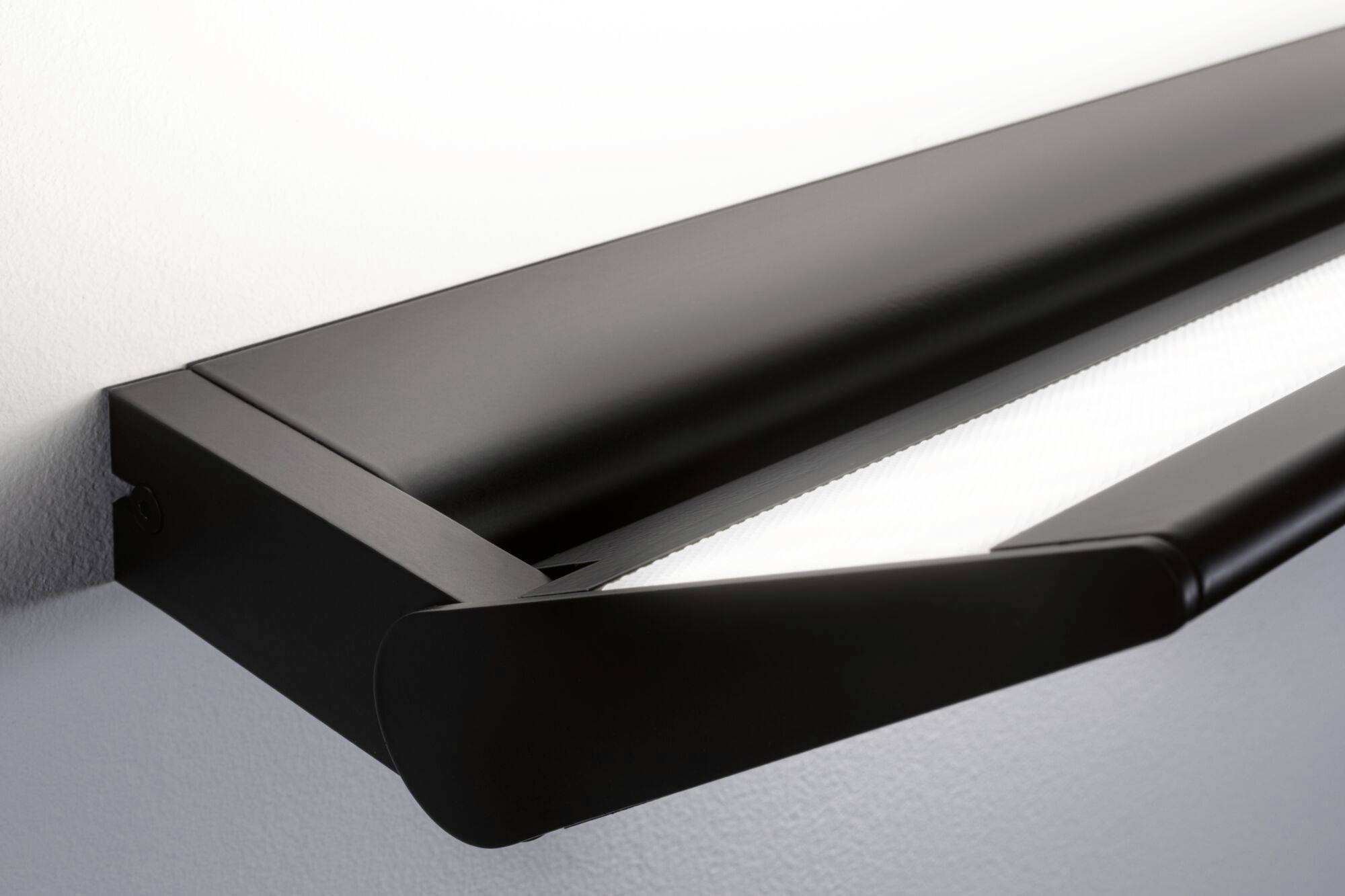 Moderní černé LED nástěnné svítidlo jemně osvětluje stěnu a zdůrazňuje čisté linie a minimalistický design.