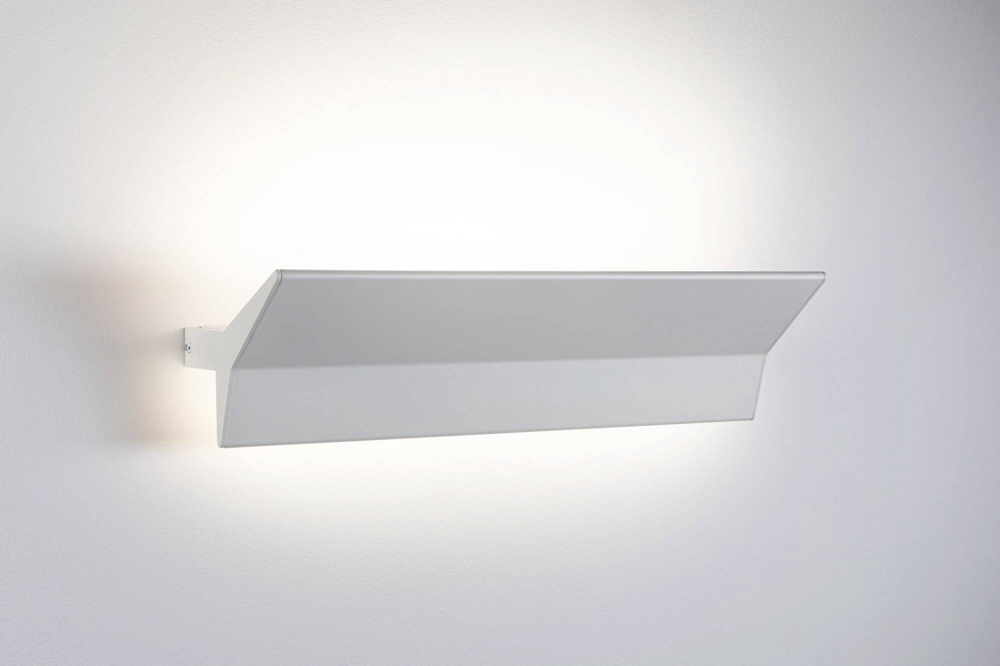 Bílé nástěnné svítidlo s moderním, geometrickým designem osvětluje stěnu jemným světlem a vytváří rovnoměrné osvětlení.