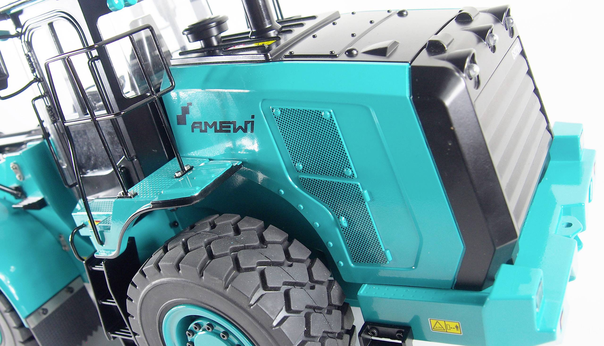 Tyrkysový modelářský traktor s detailním zpracováním a plastovými pneumatikami; na boku je uveden název značky 'Amewi'.