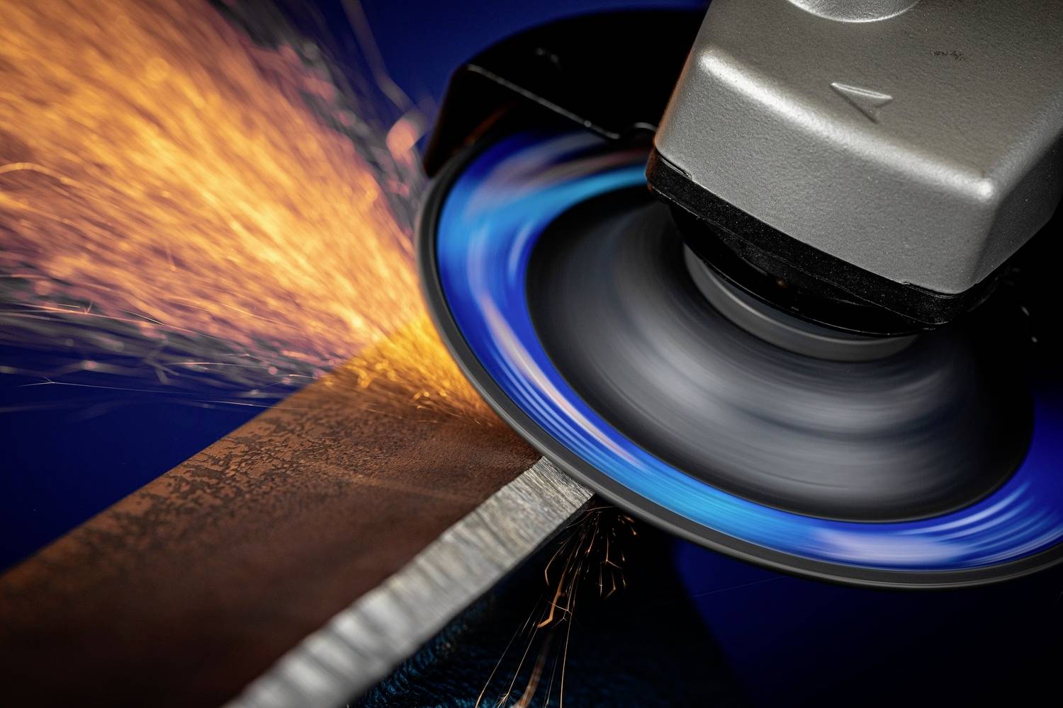 Brusná stroj opracovává kov a vytváří jiskry.