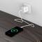 Mobilní telefon se nabíjí na dřevěném stole. Je připojen pomocí USB kabelu k adaptéru zapojenému do nástěnné elektrické zásuvky.