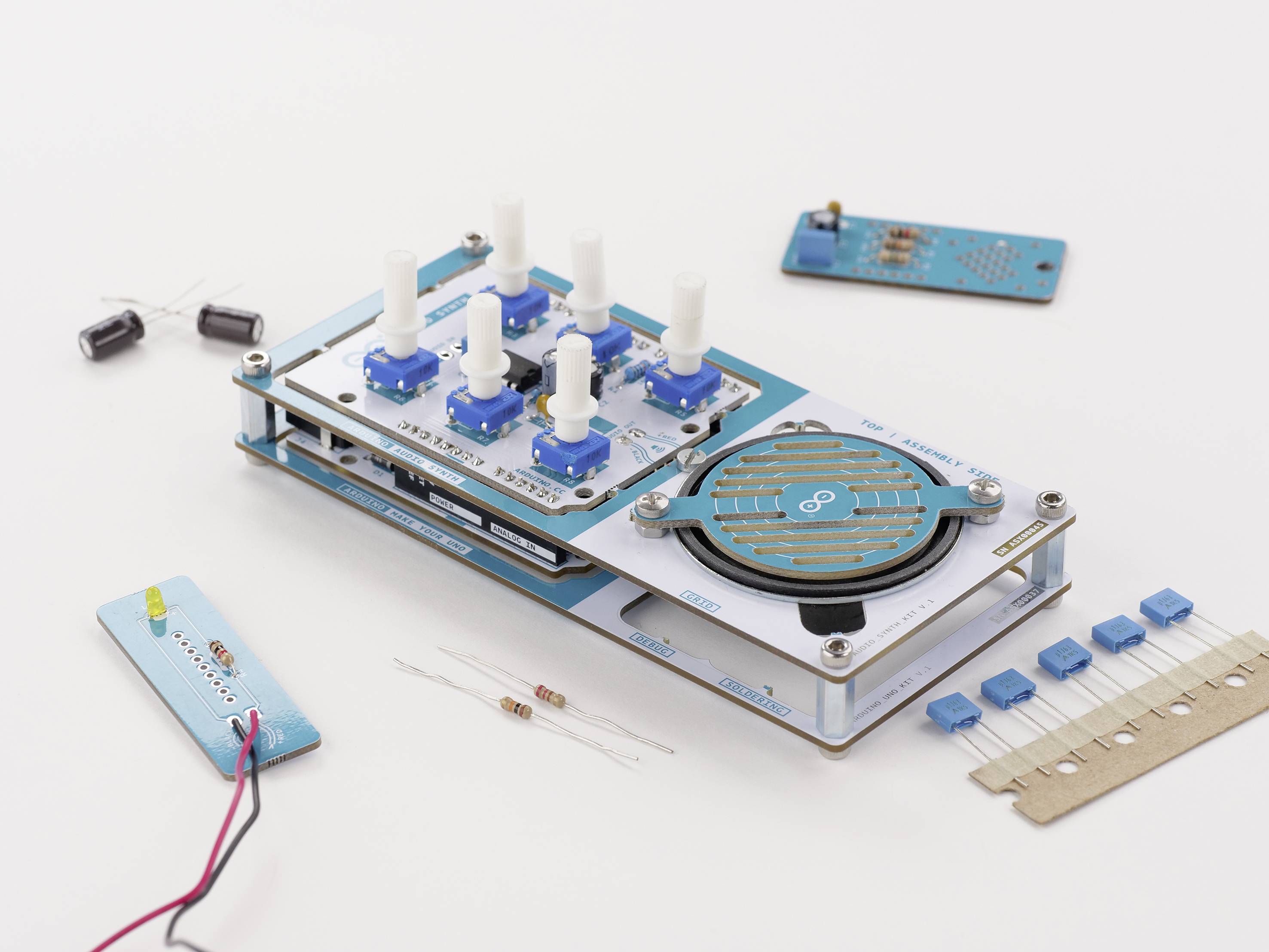 Arduino sada s mikrokontrolerem, otočnými knoflíky a elektronickými komponenty leží na stole, připravena na DIY projekt.